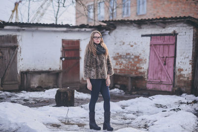 Full length portrait of woman standing on snow