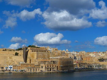 Buildings in city against cloudy sky