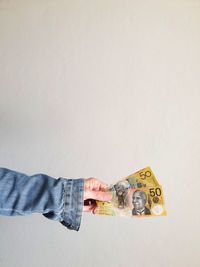 Side view of cropped female hand holding australian currency