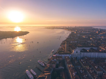 Aerial view of canal and sea against sky during sunset