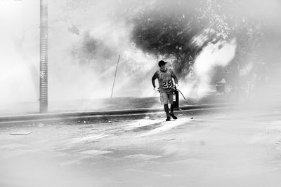 Full length rear view of man walking in water