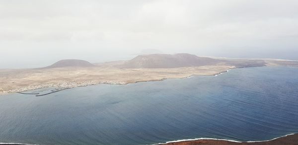 Scenic view of sea and mountains against sky