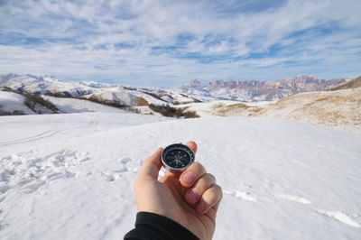 Midsection of person holding ice cream against mountains