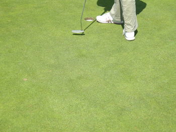Low section of golfer standing with club on golf course