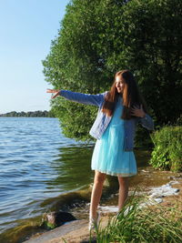 Full length of young woman standing in water