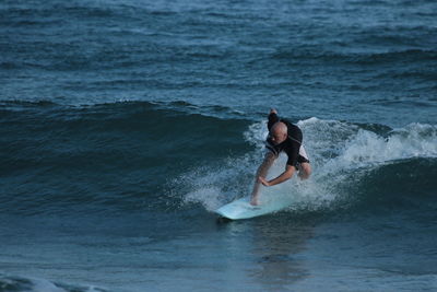 Mature man surfing in sea