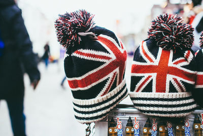 Close-up of knit hats with british flags on street for sale