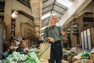 Portrait of young woman standing in market