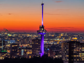 Illuminated buildings against sky during sunset