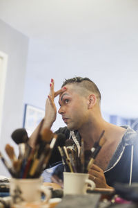 Young man applying drag makeup