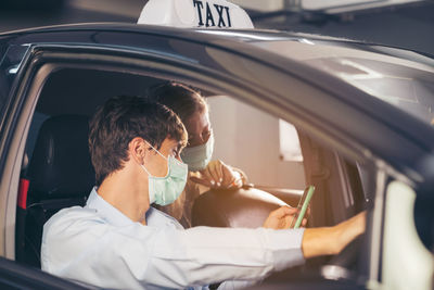 Midsection of woman using mobile phone while sitting in car