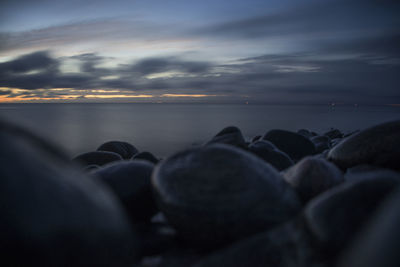 People at beach against sky during sunset