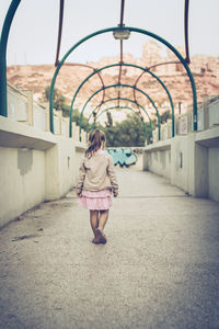 Full length rear view of girl in walkway