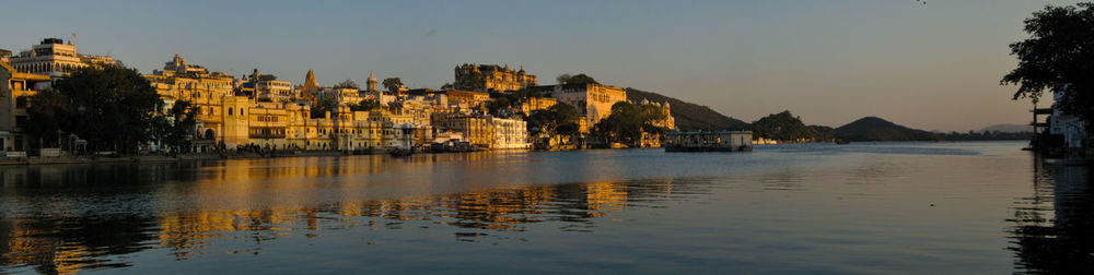 Panoramic view of lake by buildings against clear sky