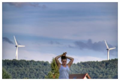 Woman standing on field against sky