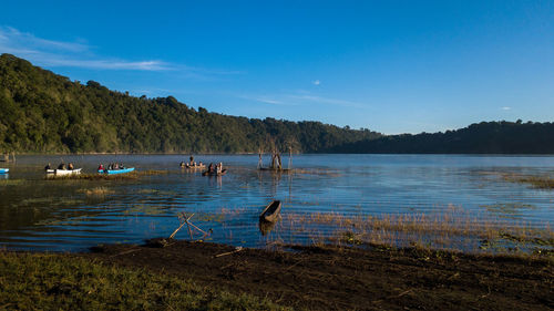 View of people in lake against sky