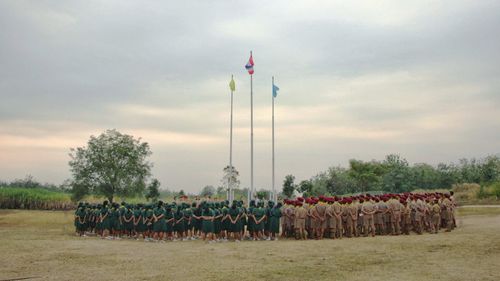 Row of flags on field against sky