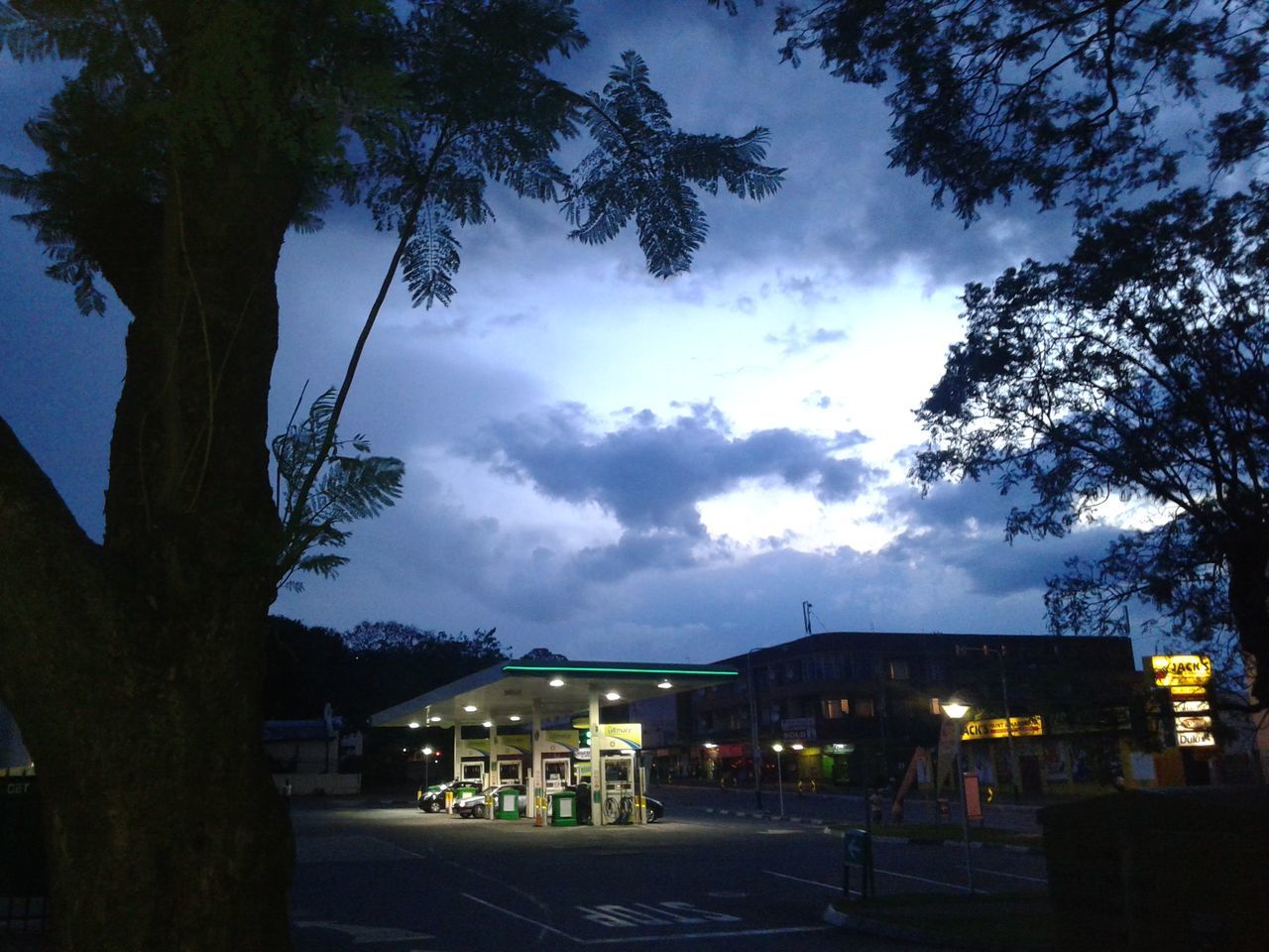 building exterior, architecture, built structure, tree, sky, house, cloud - sky, street, residential structure, road, residential building, cloud, city, silhouette, dusk, outdoors, the way forward, car, cloudy, incidental people