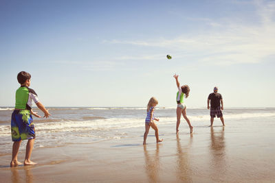 Siblings playing on shore at beach