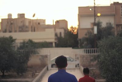 Rear view of man and buildings in city