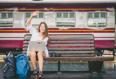 Full length portrait of woman sitting on seat