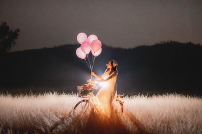 Woman holding umbrella on field