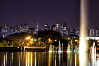 Illuminated cityscape against clear sky at night