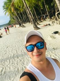 Portrait of young man wearing sunglasses on beach