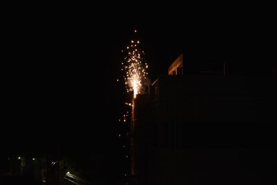 Low angle view of firework display at night