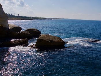 Rocks by sea against sky