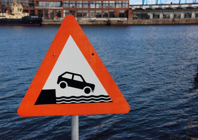 Road sign by river in city