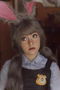 Thoughtful young woman wearing bunny ears at home