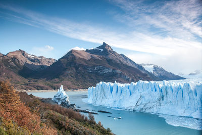 Scenic view of snowcapped mountains by sea against sky