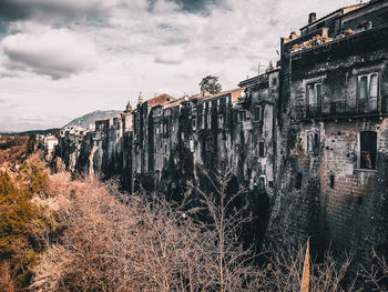 Abandoned building against cloudy sky