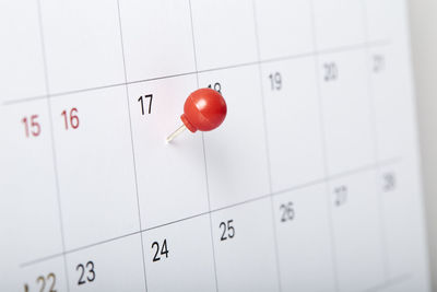 Close-up of thumbtack with calendar