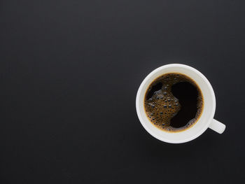 Directly above shot of coffee cup against black background