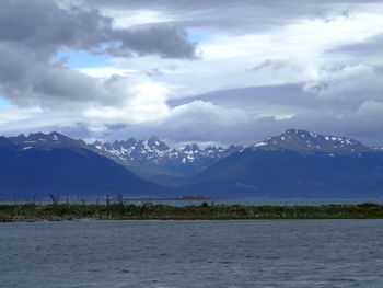 Scenic view of mountains and lake against cloudy sky