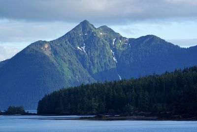 Scenic view of lake by mountains against sky