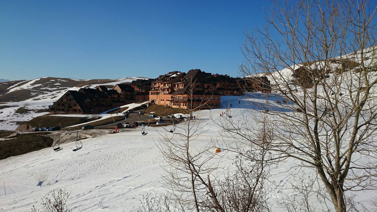 snow, clear sky, winter, cold temperature, building exterior, built structure, architecture, blue, mountain, season, copy space, house, residential structure, bare tree, nature, residential building, mountain range, tree, day, beauty in nature