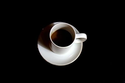 Close-up of coffee cup over black background