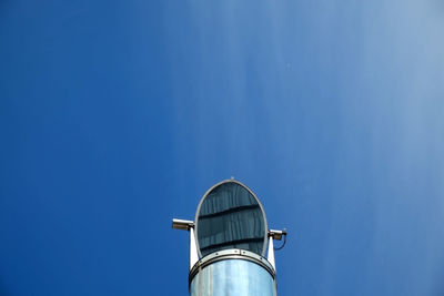 Low angle view of mirror at against blue sky