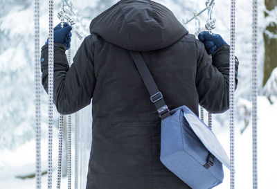 Rear view of man holding ropes during winter