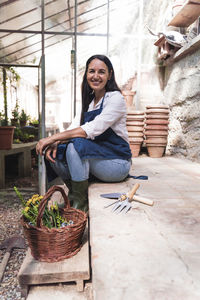 Portrait of smiling young woman sitting in basket