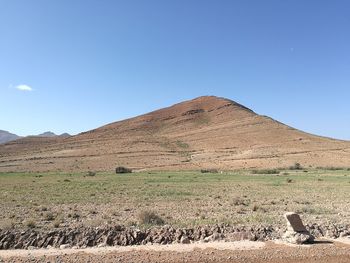 Scenic view of desert against clear blue sky