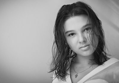 Teenage girl standing against wall