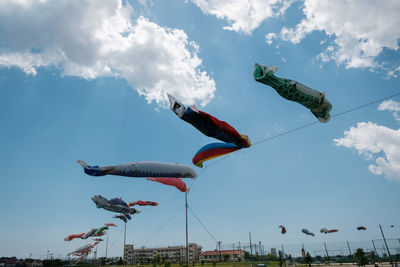 Low angle view of fish streamers  flying against sky