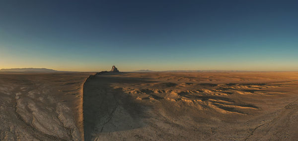 Scenic view of shiprock against clear sky during sunset