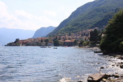 Scenic view of river by mountains against sky