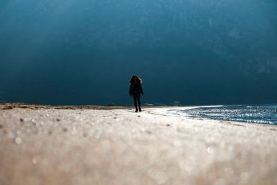 Rear view of woman standing on beach