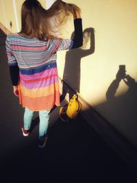 Rear view of girl standing with toy